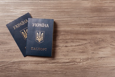 Photo of Ukrainian internal passports on wooden background, top view. Space for text