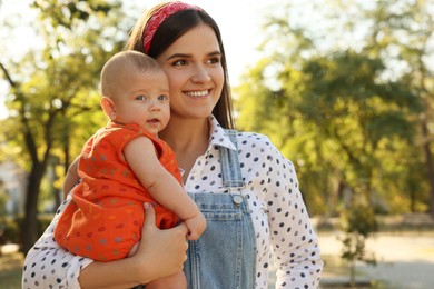 Photo of Young mother with her cute baby in park on sunny day