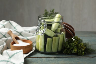 Photo of Pickling jar with fresh ripe cucumbers on blue wooden table