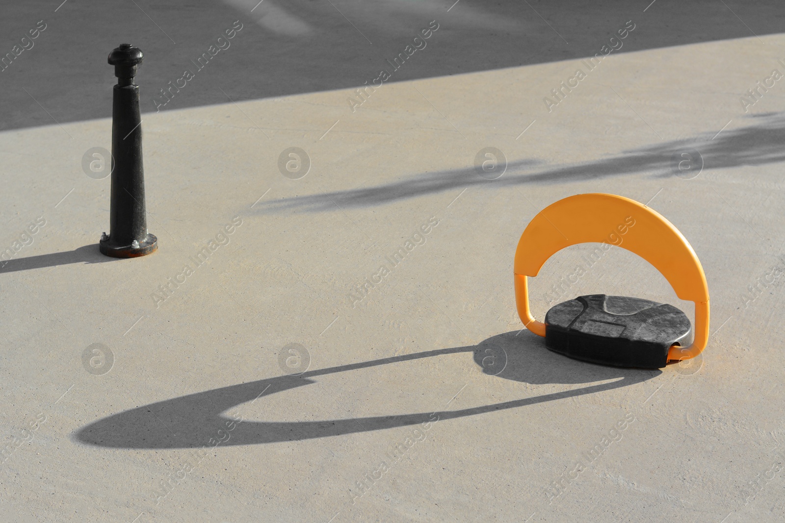 Photo of Parking barrier with No Stopping road sign and pole on asphalt outdoors