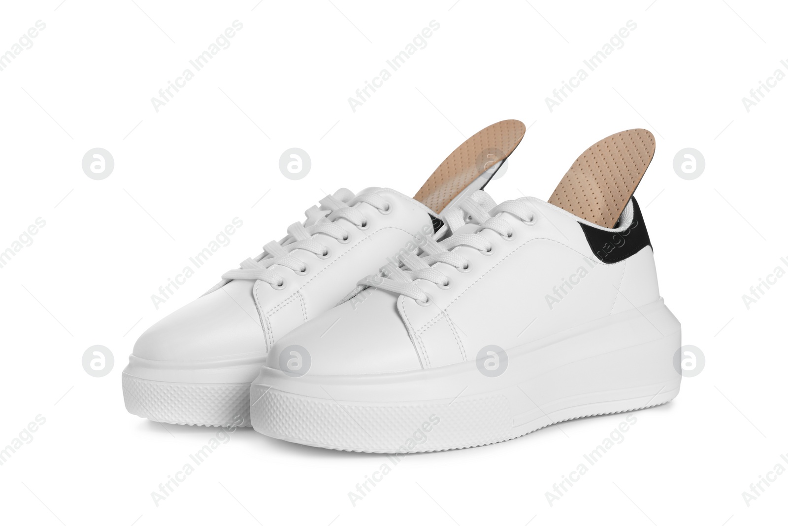 Photo of Orthopedic insoles in shoes on white background
