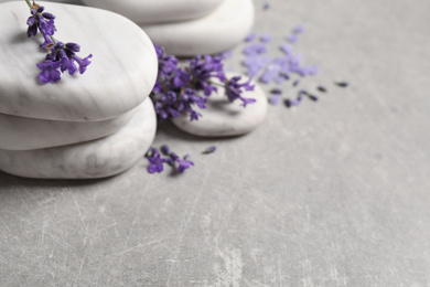 Photo of Stones, sea salt and lavender flowers on grey table, closeup. Space for text