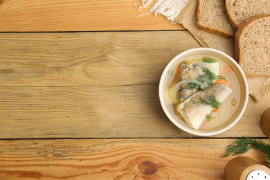 Photo of Delicious fish soup served on wooden table, flat lay. Space for text