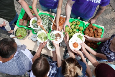 Photo of Volunteers serving food for poor people outdoors, top view