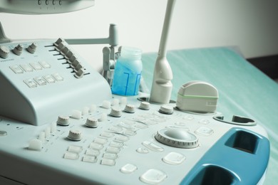 Ultrasound control panel with ultrasonic transducers and transmission gel in hospital, closeup. Medical equipment