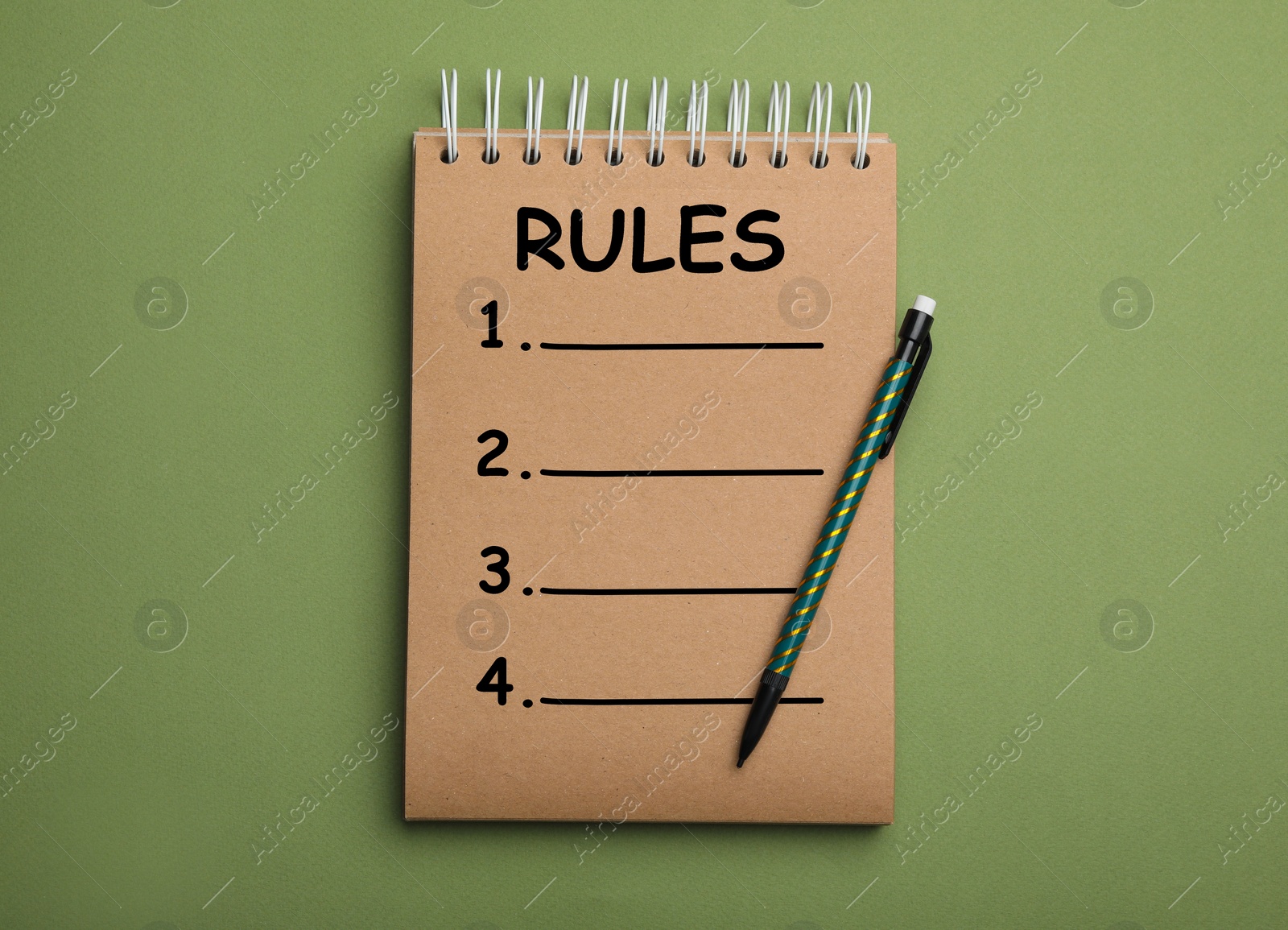 Image of Kraft notebook with list of rules and pencil on green background, top view