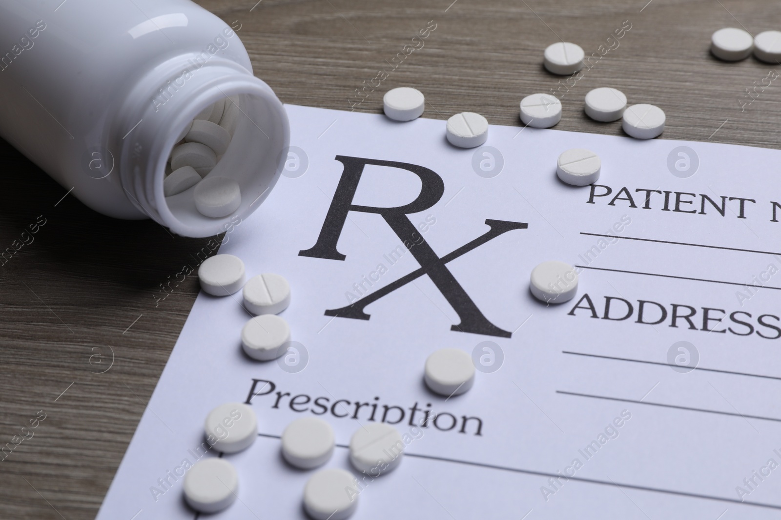 Photo of Medical prescription form, pills and bottle on wooden table, closeup