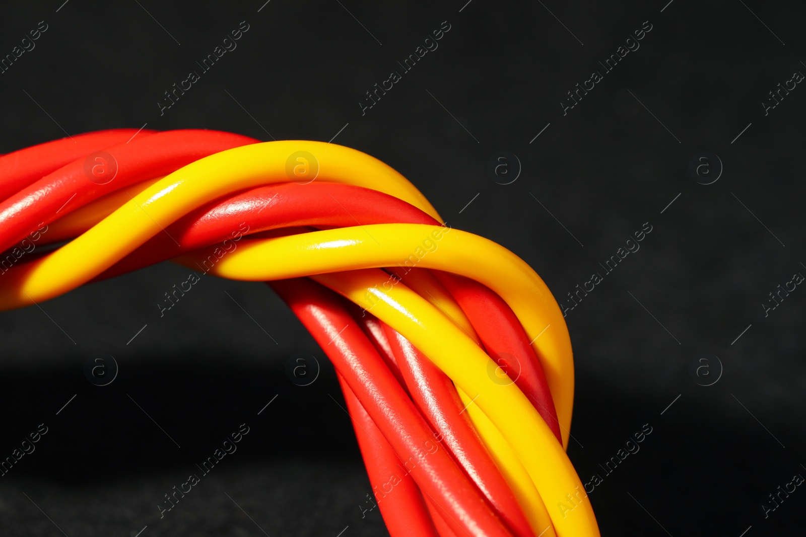 Photo of Electrical wires on black background, closeup. Space for text