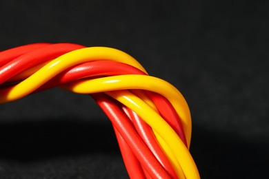 Photo of Electrical wires on black background, closeup. Space for text