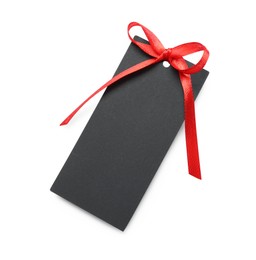 Photo of Blank black gift tag with red satin ribbon on white background, top view. Space for design