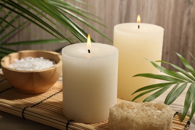 Photo of Composition with spa supplies and palm leaves on wooden table