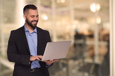 Image of Successful lawyer with laptop on blurred background, space for text