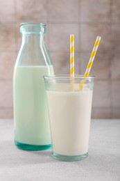 Photo of Glassware with tasty milk on gray light table