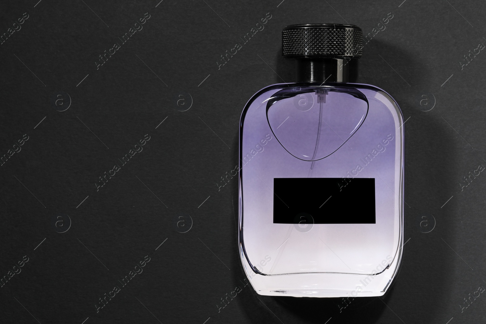 Photo of Luxury men`s perfume in bottle on black background, top view. Space for text