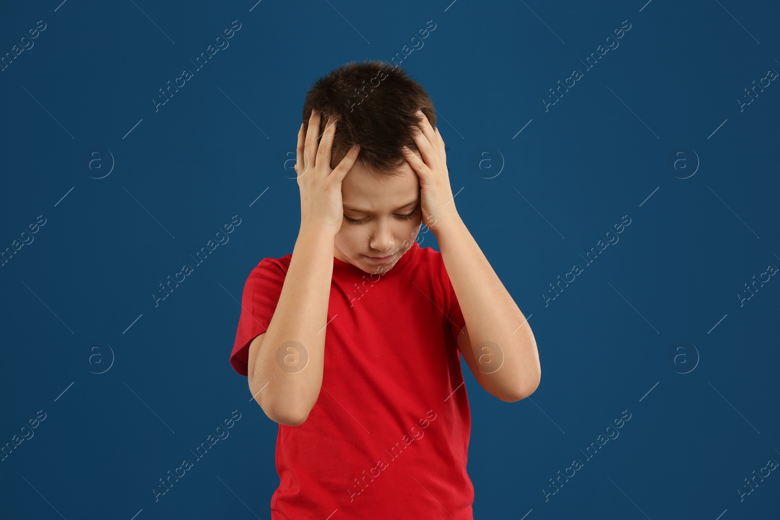 Photo of Portrait of emotional preteen boy on blue background