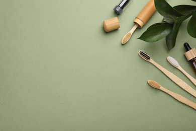 Photo of Flat lay composition with bamboo toothbrushes on green background, space for text