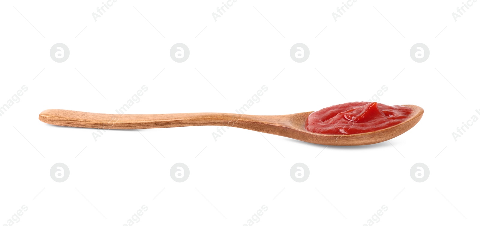 Photo of Ketchup in wooden spoon isolated on white