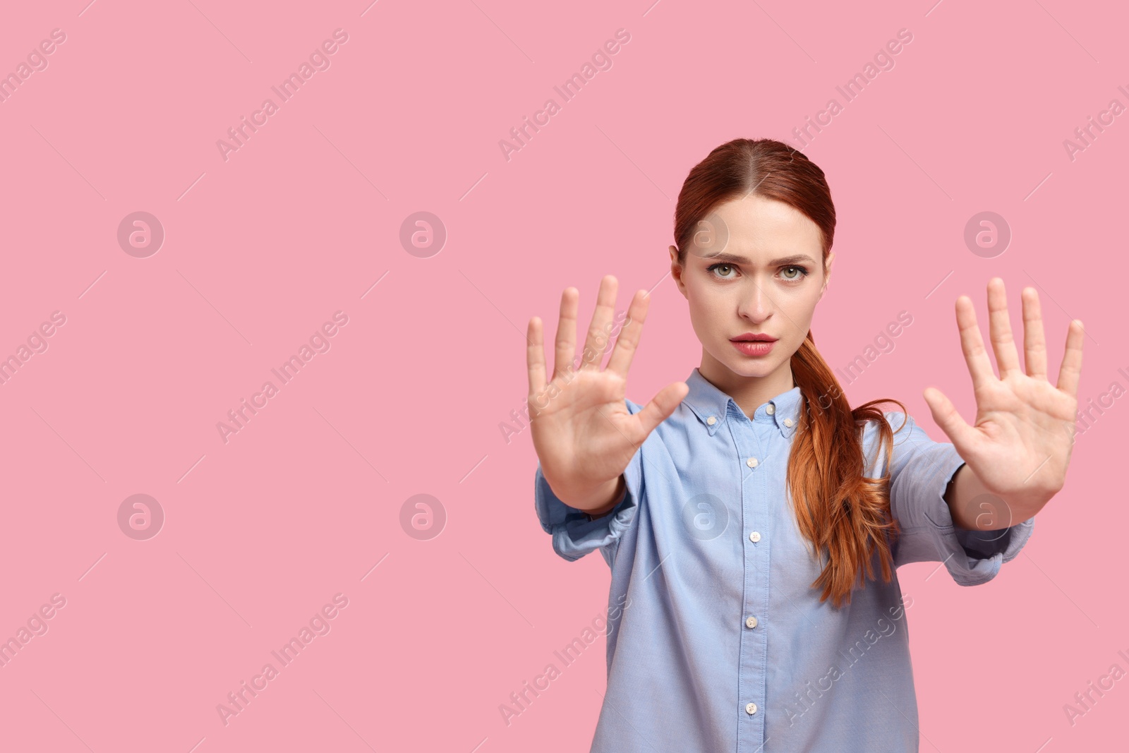 Photo of Woman showing stop gesture on pink background, space for text