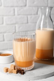 Photo of Delicious eggnog with anise and sugar on white table