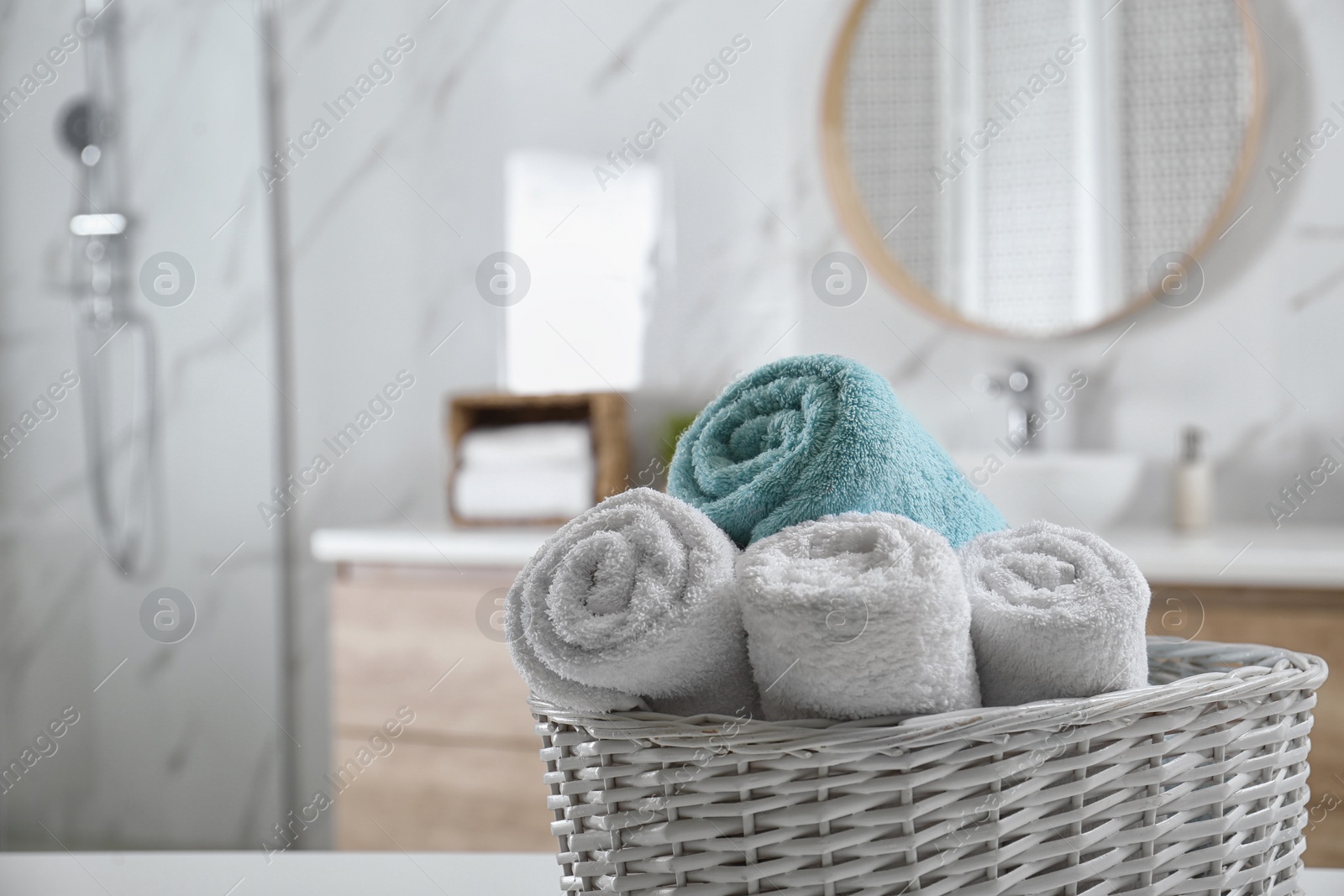 Photo of Wicker basket with clean soft towels in bathroom. Space for text