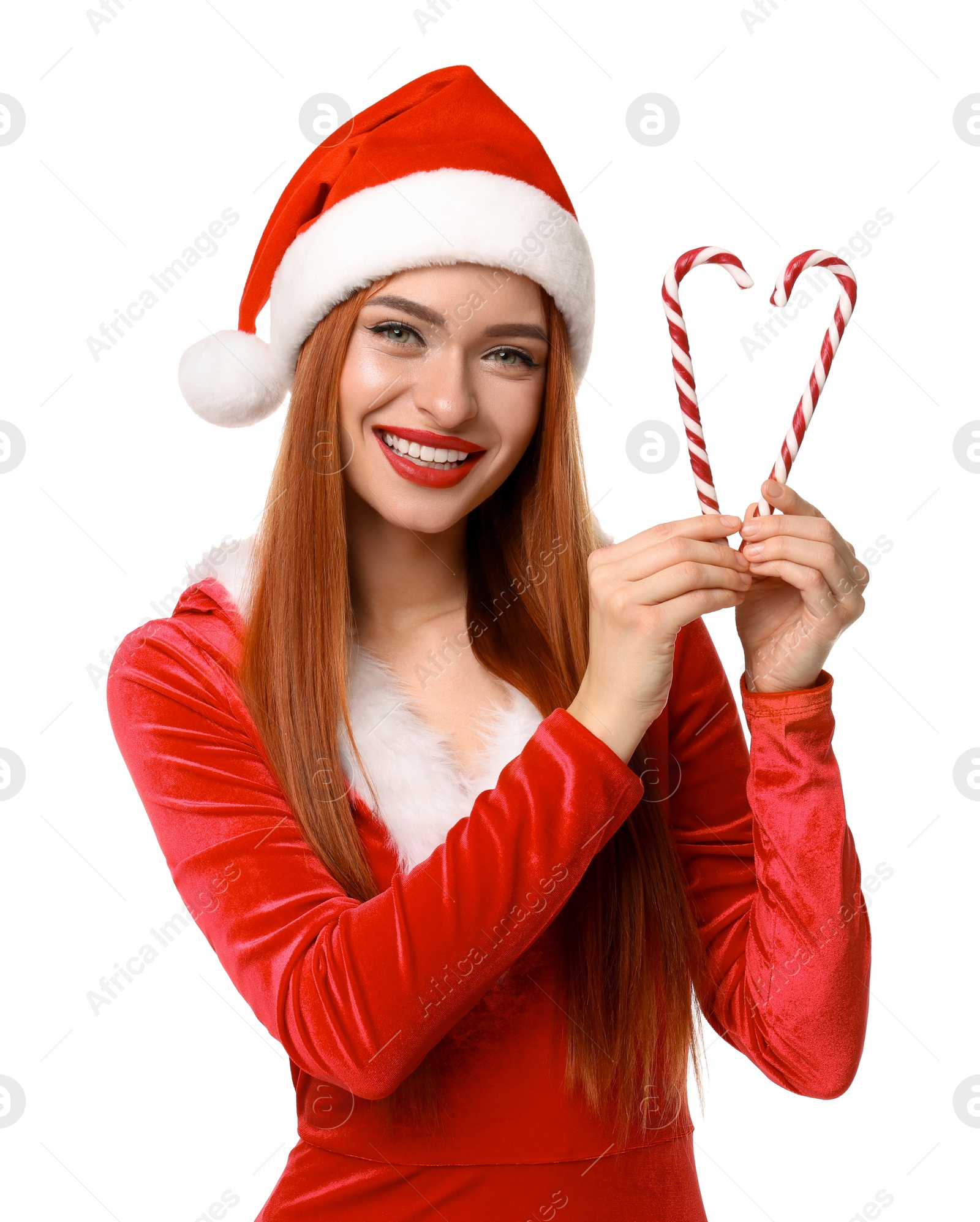 Photo of Young woman in red dress and Santa hat with candy canes on white background. Christmas celebration