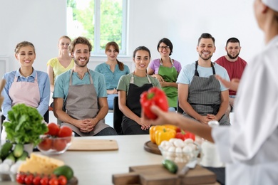 Photo of Group of people and female chef at cooking classes