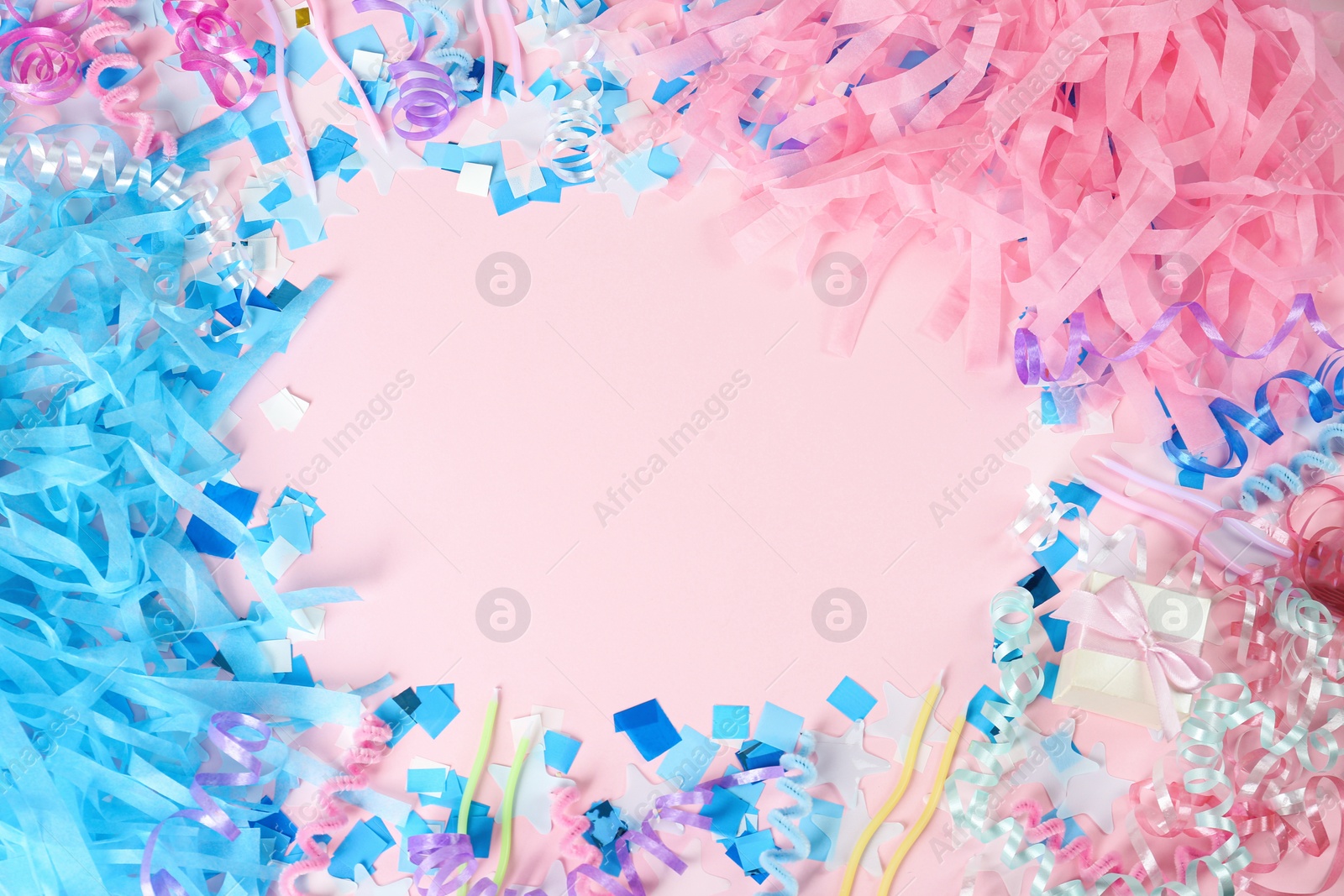 Photo of Frame of colorful serpentine streamers and other party accessories on pink background, flat lay. Space for text