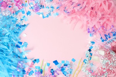 Photo of Frame of colorful serpentine streamers and other party accessories on pink background, flat lay. Space for text