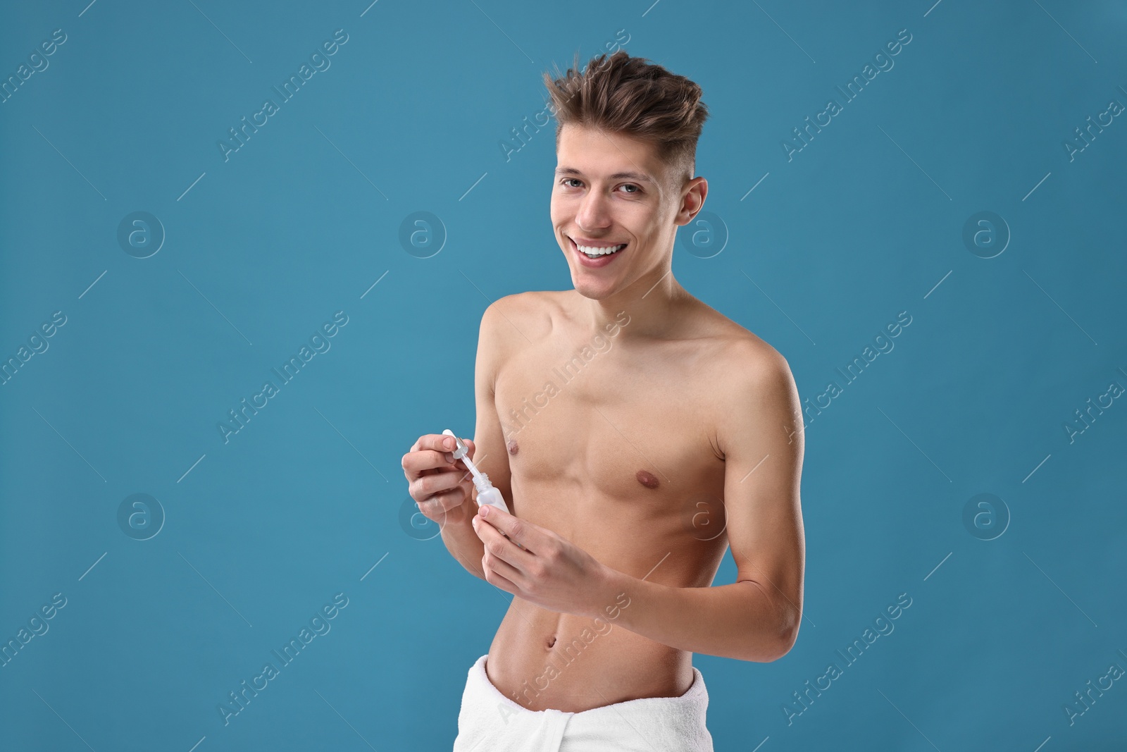 Photo of Handsome man with serum on blue background