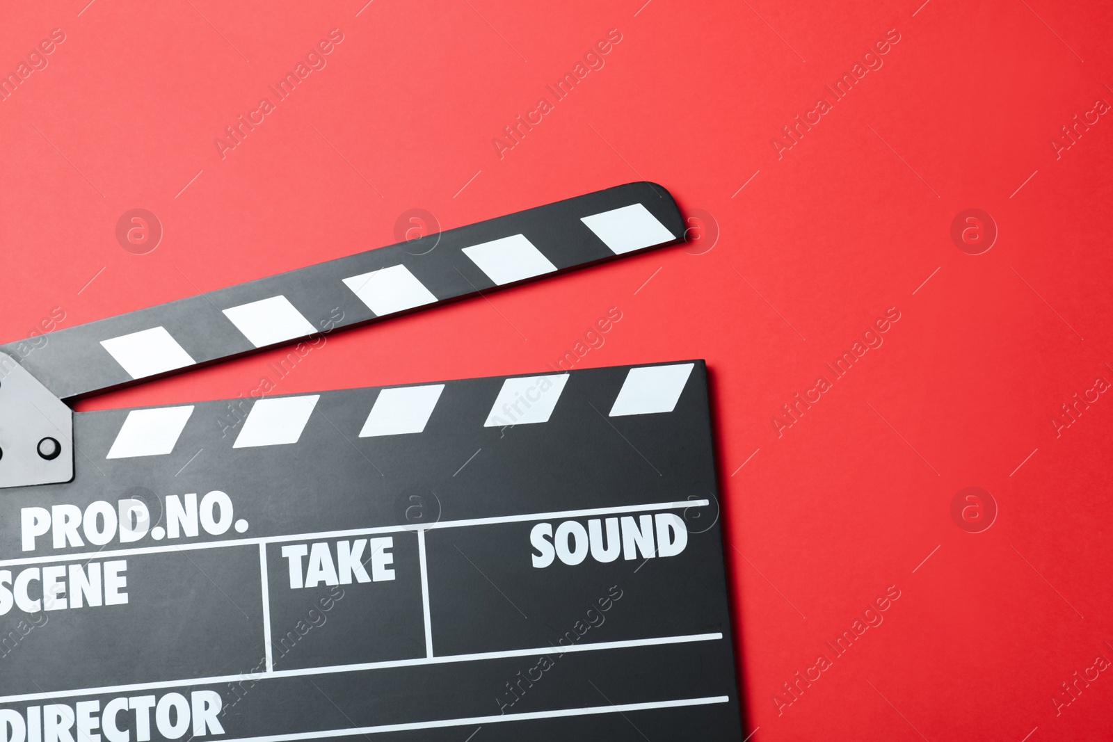 Photo of Clapper board on red background, top view. Cinema production