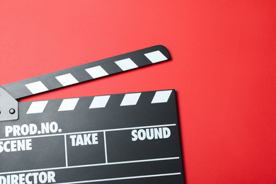 Photo of Clapper board on red background, top view. Cinema production