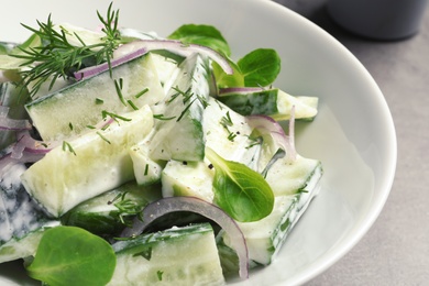 Photo of Plate with creamy cucumber salad on table, closeup