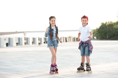 Photo of Little children roller skating on city street