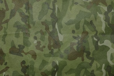 Photo of Texture of camouflage fabric as background, top view