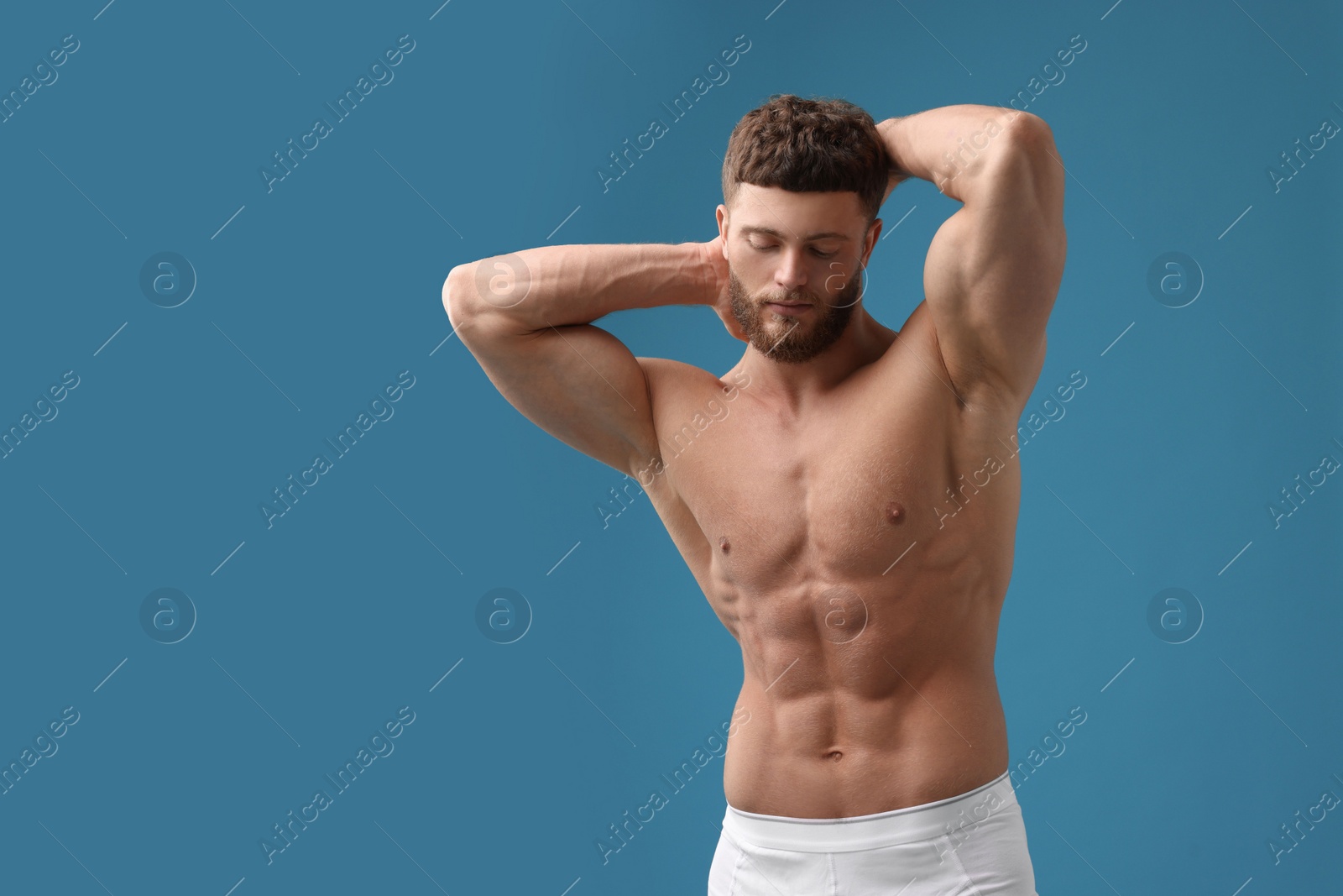 Photo of Handsome muscular man on light blue background, space for text. Sexy body