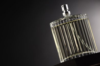 Photo of Luxury men`s perfume in bottle against grey background, space for text