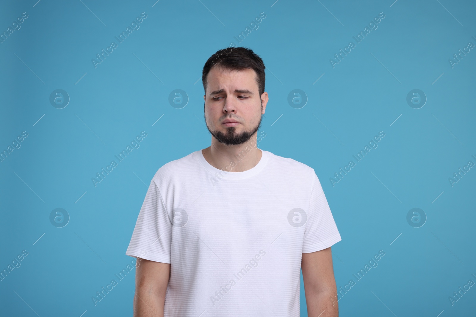 Photo of Portrait of sad man on light blue background