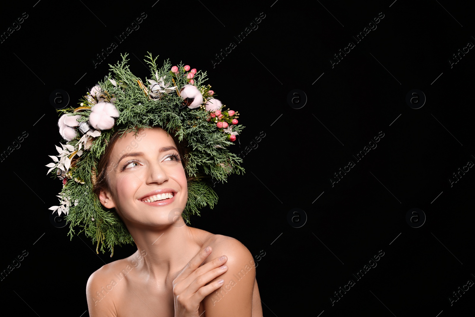 Photo of Happy young woman wearing wreath on black background. Space for text