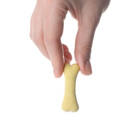 Woman holding bone shaped dog cookie on white background, closeup