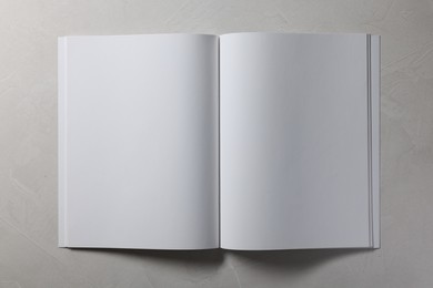 Photo of Open notebook with blank pages on grey textured background, top view. Mockup for design