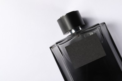 Luxury men`s perfume in bottle on white background, top view. Space for text