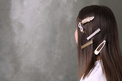 Photo of Young woman with beautiful hair clips on grey background, space for text