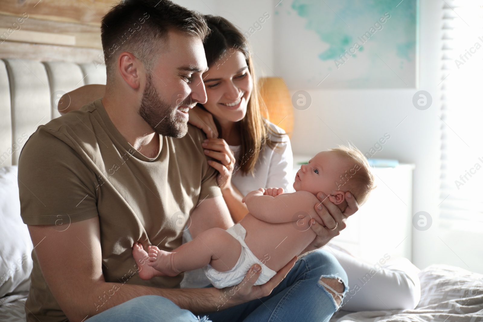 Photo of Happy couple with their newborn baby at home