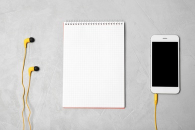 Photo of Flat lay composition with headphones, smartphone and notebook on grey background. Space for text