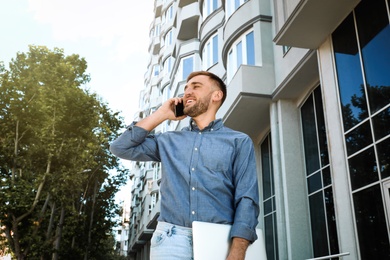 Young man talking on smartphone on city street