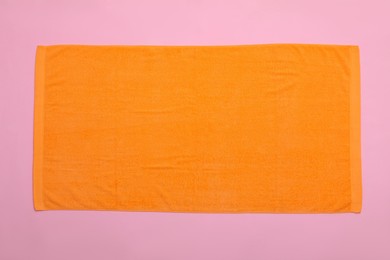 Photo of Orange beach towel on pink background, top view