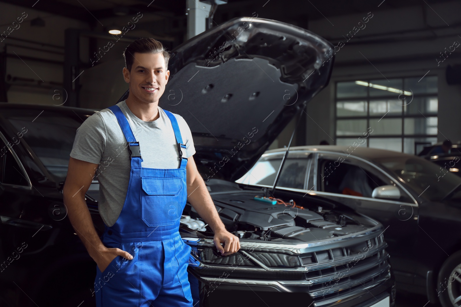 Photo of Mechanic near automobile in service center, space for text. Car diagnostic