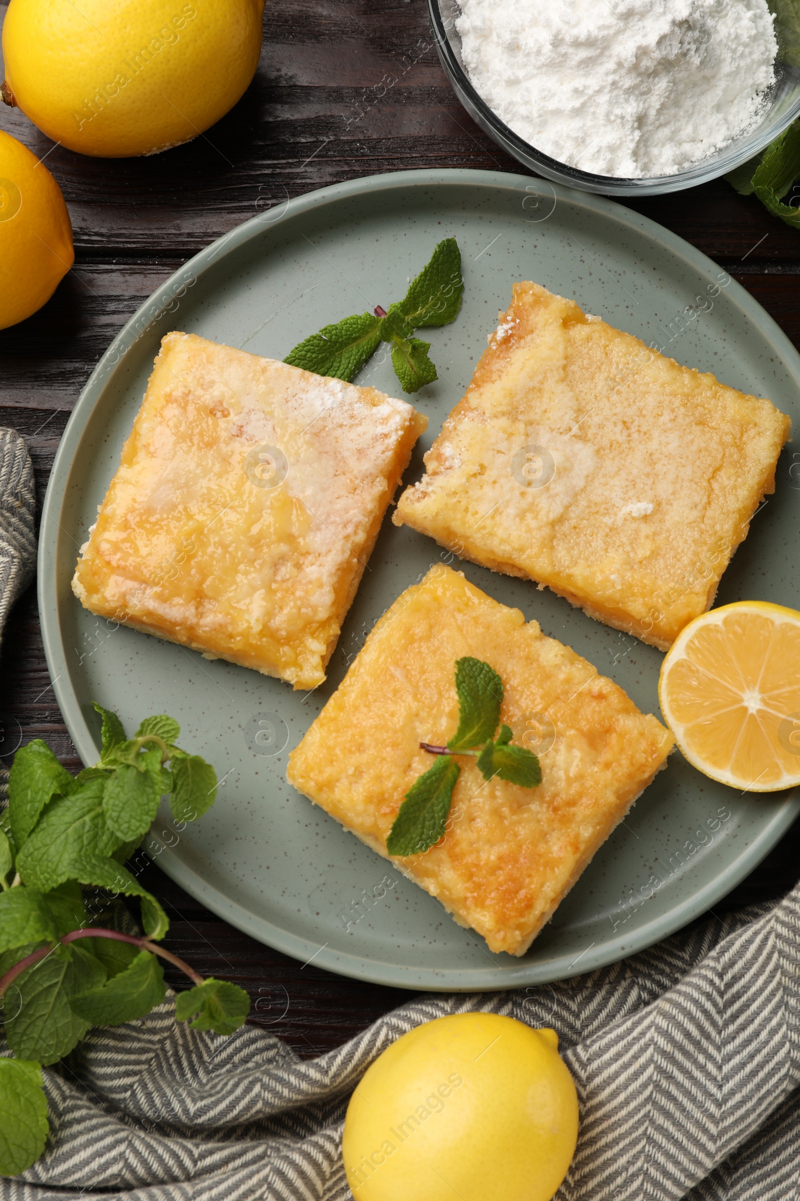 Photo of Tasty lemon bars served on wooden table, flat lay