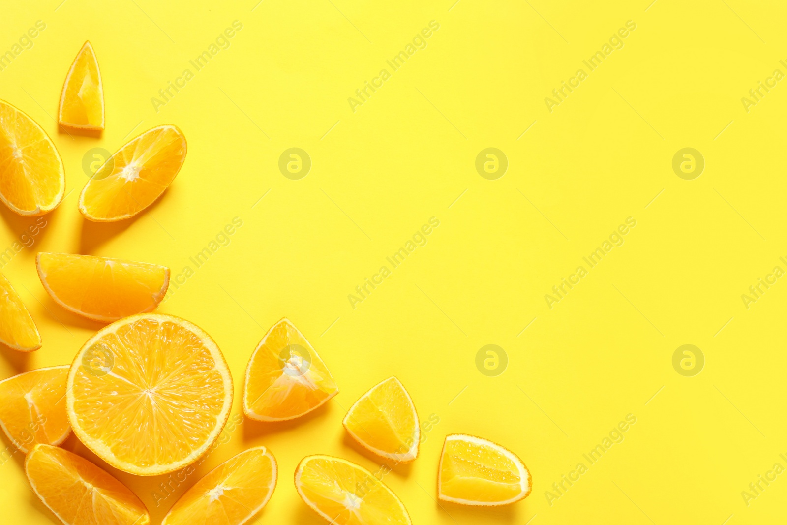 Photo of Flat lay composition with orange slices and space for text on color background