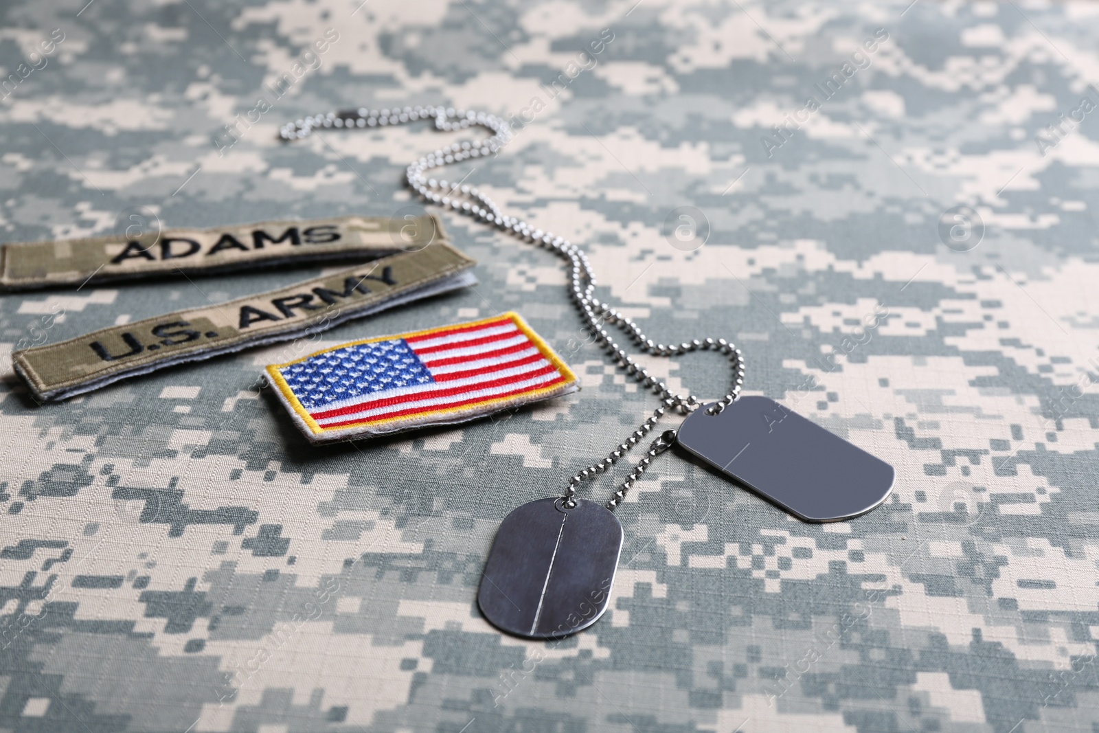 Photo of Military ID tags and US army patches on camouflage background